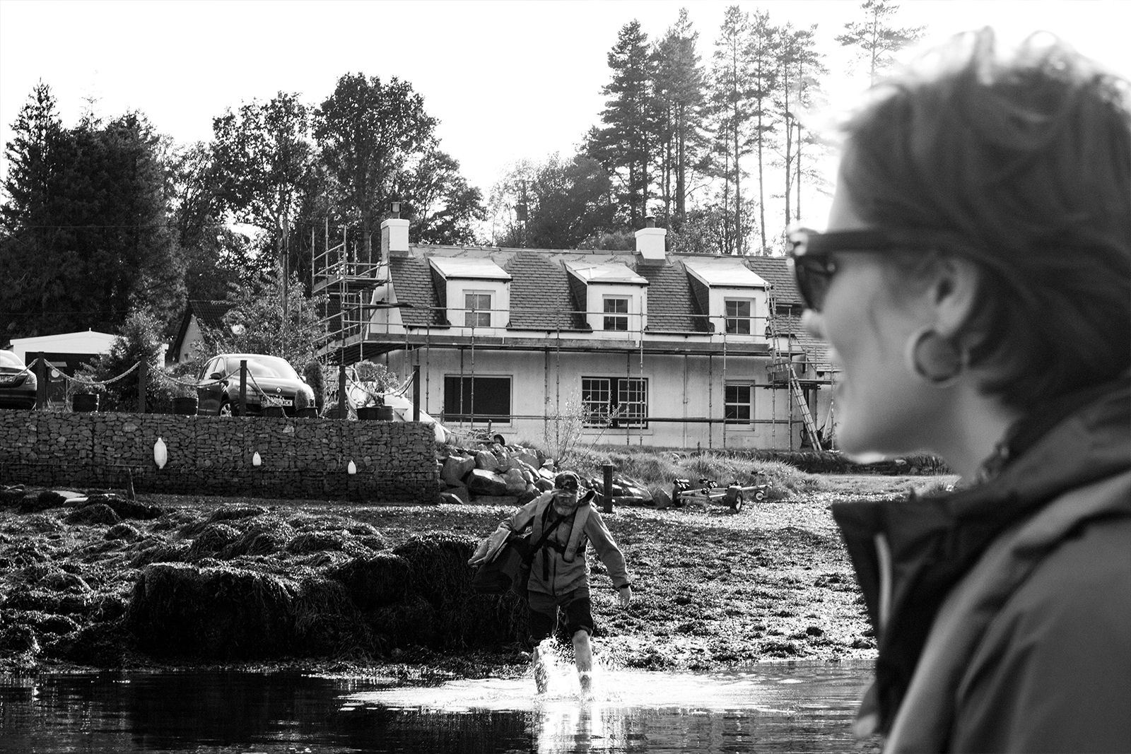 Loch Fyne 2019 O Street Fishing Trip. Graphic designer Tessa Simpson is in the foreground, out of focus with Neil Wallace wading into the loch in the background.